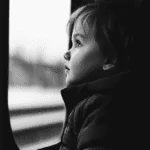 kid sitting near window